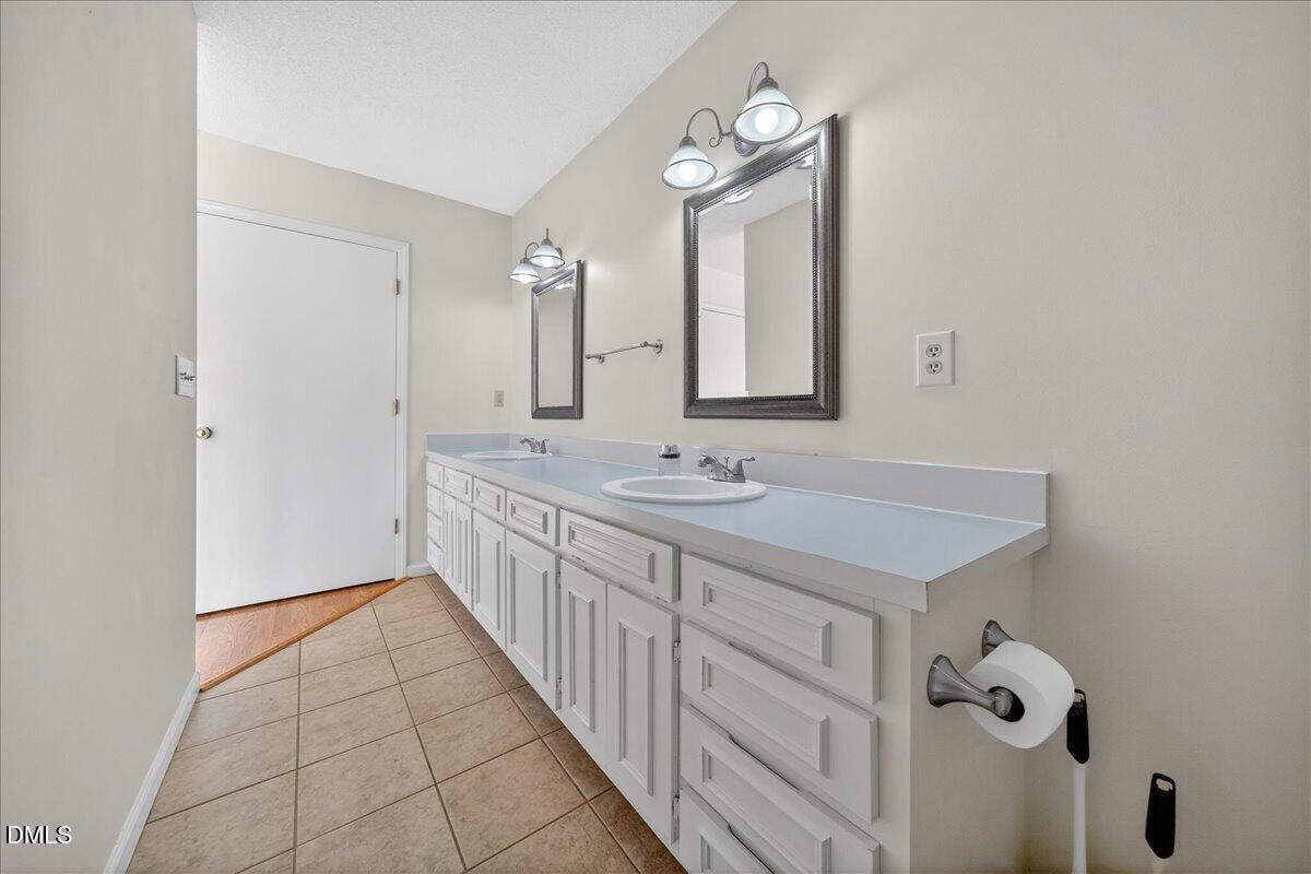 180 Manor Drive Timberlake, NC 27583 - Photo 22 of 85 a bathroom with 2 sink and a mirror