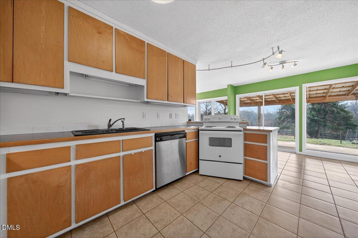180 Manor Drive Timberlake, NC 27583 - Photo 26 of 85 a kitchen with stainless steel appliances granite countertop a stove a sink and a refrigerator