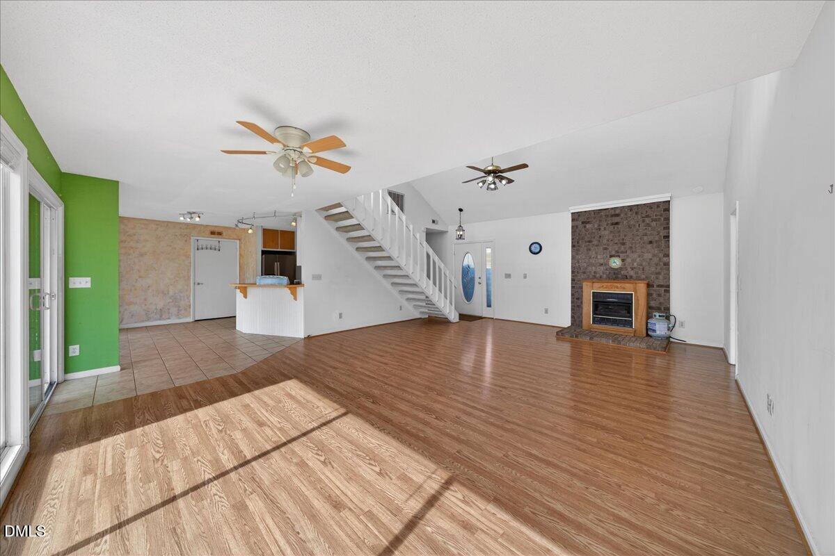 180 Manor Drive Timberlake, NC 27583 - Photo 8 of 85 a view of an empty room with wooden floor and a ceiling fan