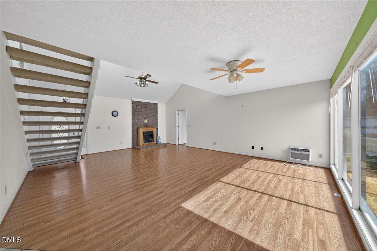 180 Manor Drive Timberlake, NC 27583 - Photo 9 of 85 an empty room with wooden floor and a ceiling fan