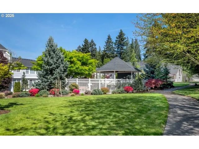 a kitchen with stainless steel appliances kitchen island granite countertop a stove a sink dishwasher a dining table and chairs with wooden floor