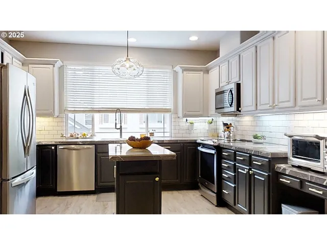 a kitchen with stainless steel appliances granite countertop a sink dishwasher stove and oven with cabinets