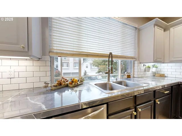 a kitchen with stainless steel appliances granite countertop a sink a stove and a microwave