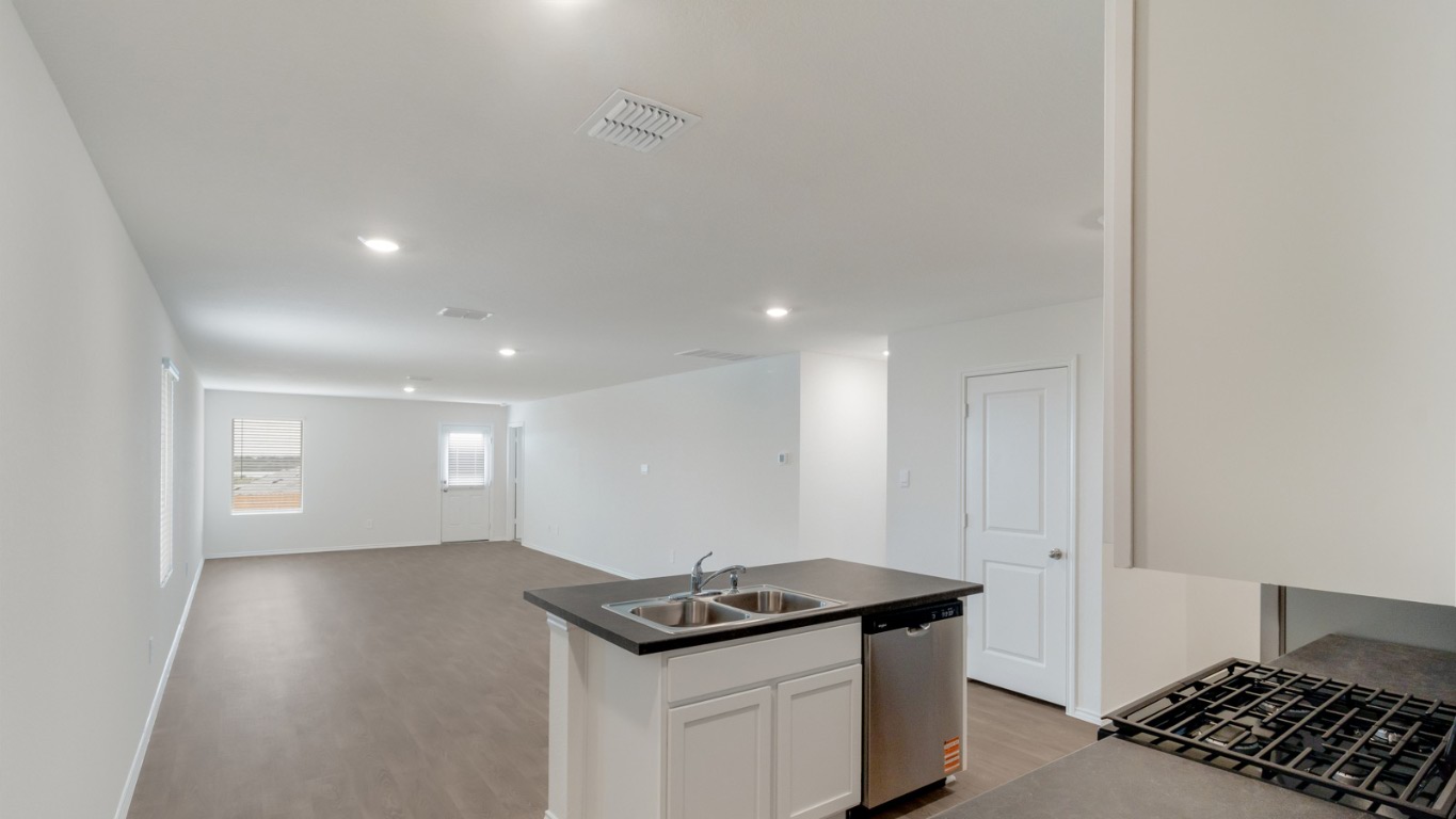 345 Bull Lake Circle Buda, TX 78610 - Photo 4 of 17 a kitchen with granite countertop a stove and a sink