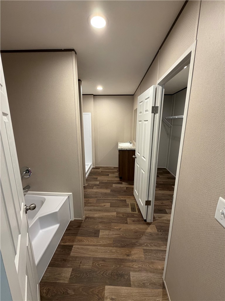 1411 Slaton Road Townville, SC 29689 - Photo 12 of 17 Rich wood-look flooring guides the eye through this spacious bathroom suite.