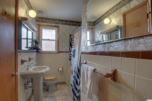a bathroom with a sink a toilet and mirror