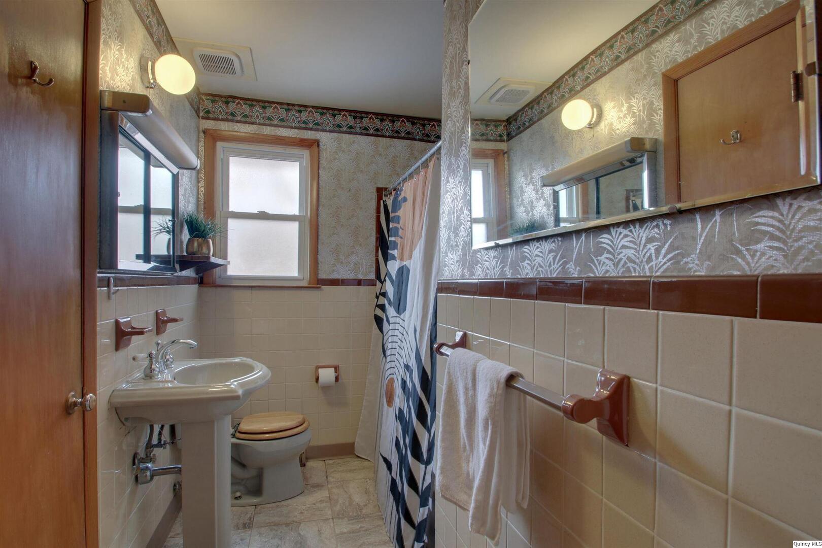 523 Temple Street Quincy, IL 62305 - Photo 21 of 23 a bathroom with a sink a toilet and mirror