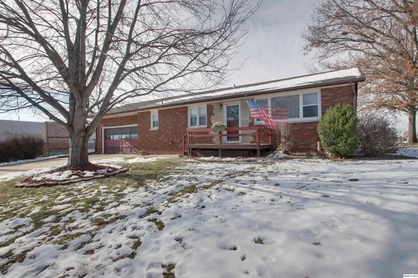 a front view of a house with a yard and seating space