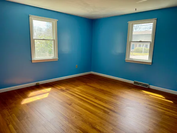a view of a room with wooden floor and windows