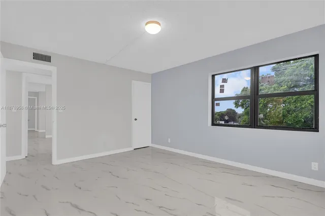 an empty room with window and ceiling fan