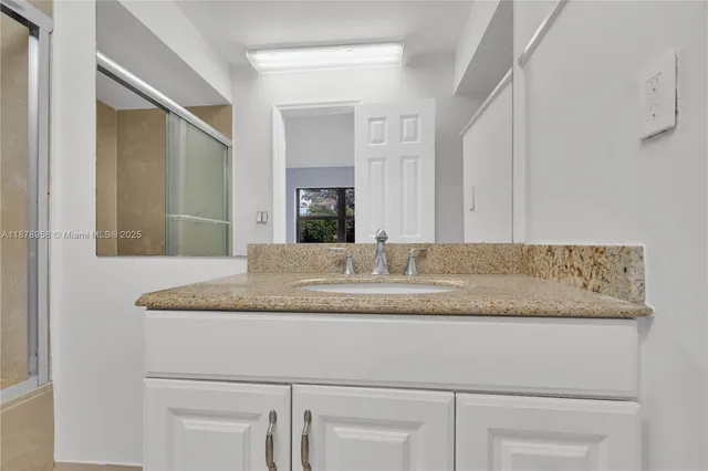 a bathroom with a granite countertop sink a toilet and a mirror