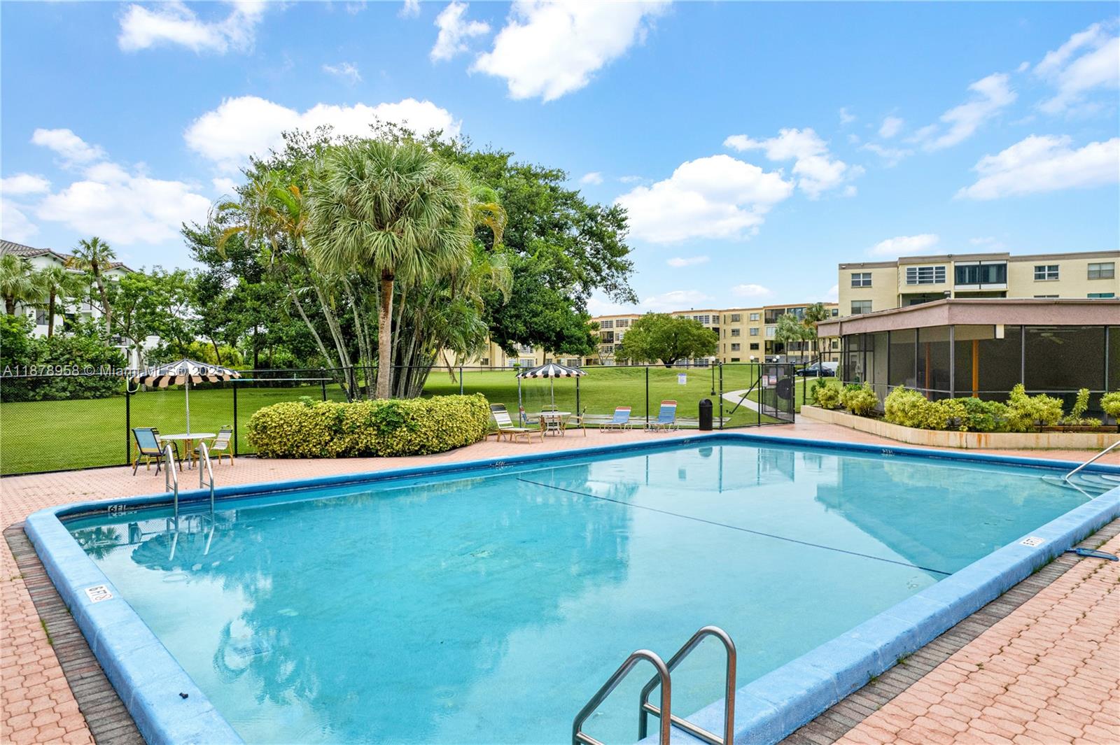 9355 Southwest 8th Street, Unit 425 Boca Raton, FL 33428 - Photo 32 of 42 a view of a swimming pool with a garden and plants