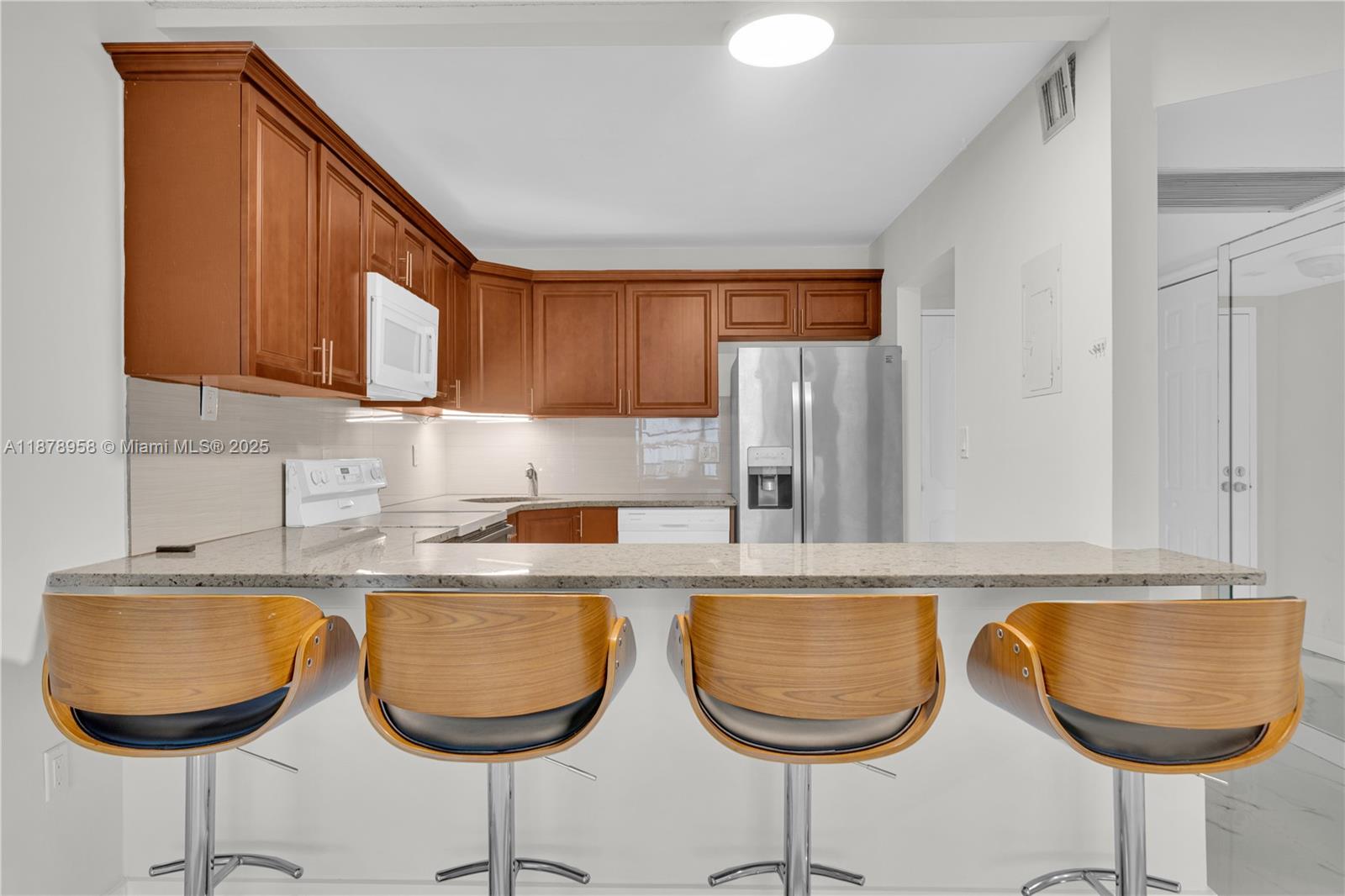 9355 Southwest 8th Street, Unit 425 Boca Raton, FL 33428 - Photo 6 of 42 a kitchen with granite countertop a dining table chairs and a sink