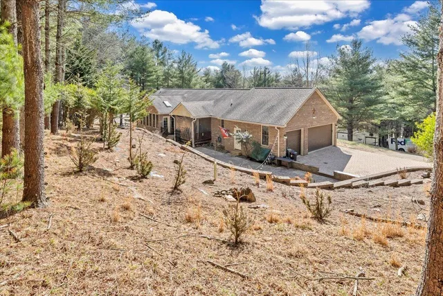 an aerial view of a houses with a lush green forest