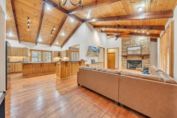 a large white kitchen with stainless steel appliances granite countertop a stove a sink dishwasher and cabinets with wooden floor