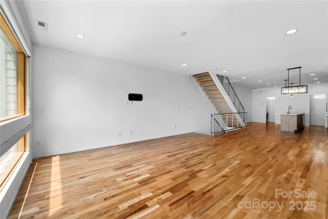 a view of empty room with wooden floor and windows