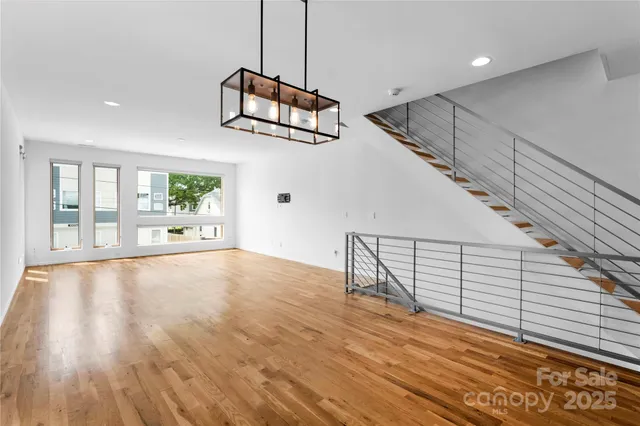 a kitchen with stainless steel appliances kitchen island a refrigerator and a wooden floor