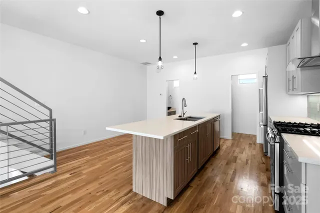 a kitchen with granite countertop a sink stove and refrigerator