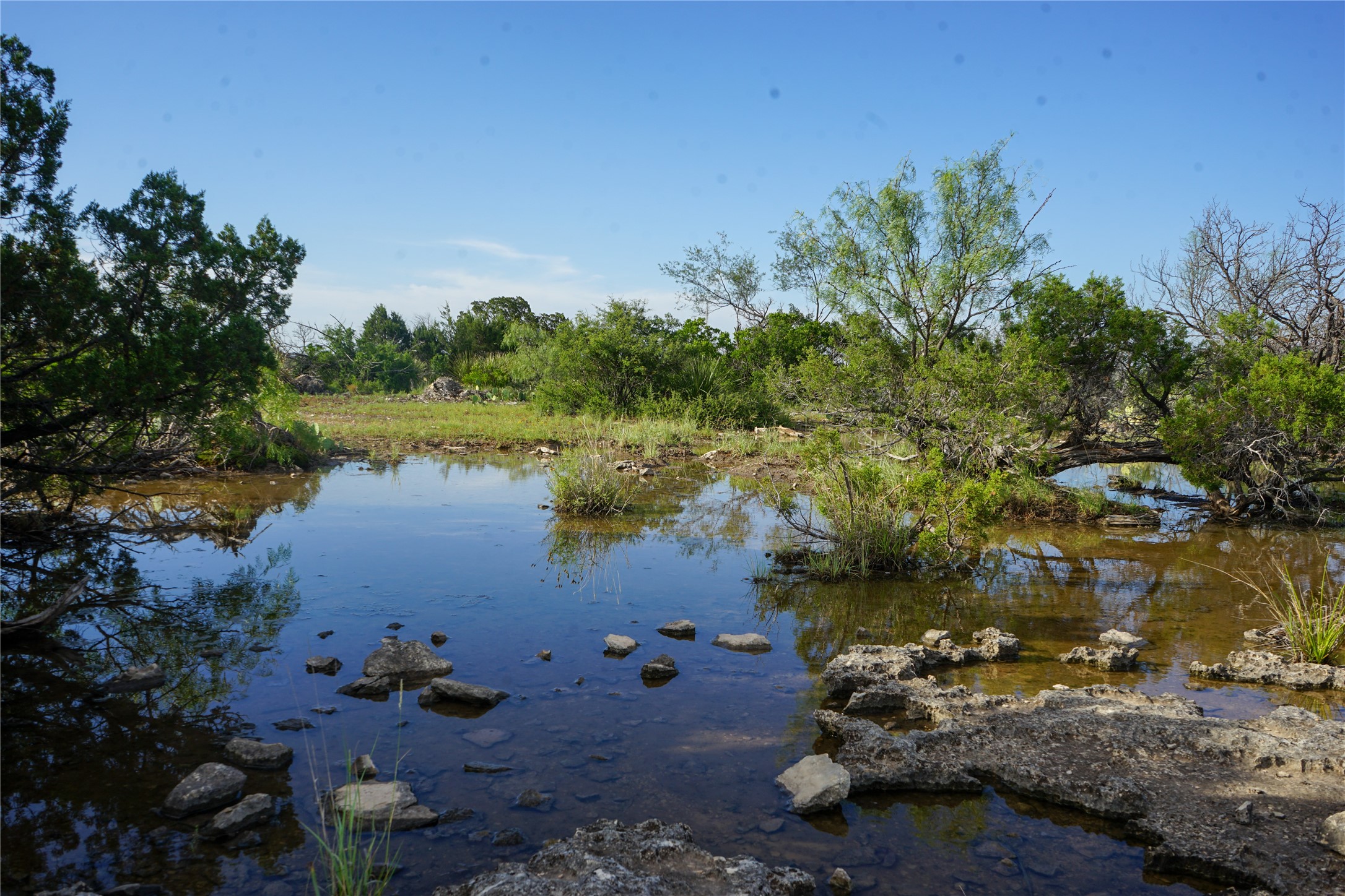 0 Rr 1024 Comstock, TX 78837 - Photo 10 of 50 a view of a lake with lawn chairs under an umbrella