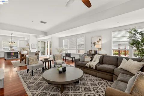 a living room with furniture kitchen view and a large window