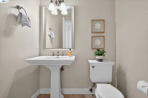 a bathroom with a toilet a sink and mirror
