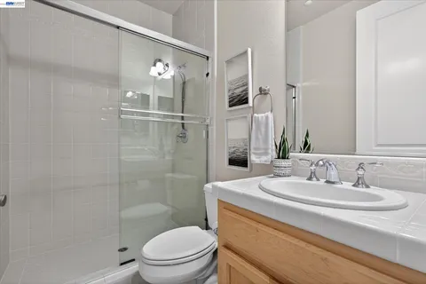 a bathroom with a sink a toilet a mirror and shower