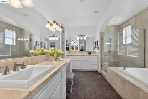 a large bathroom with a double vanity sink large mirror and a bathtub