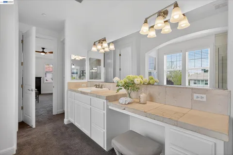 a bathroom with a granite countertop sink a toilet and a mirror