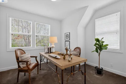 a dining room with furniture and potted plants
