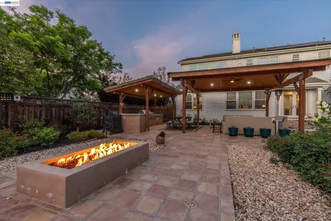 a view of swimming pool with sitting area in backyard