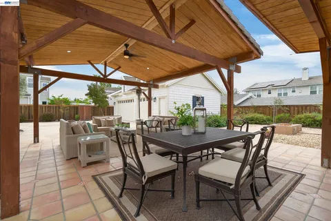 a view of a patio with a table chairs and a backyard
