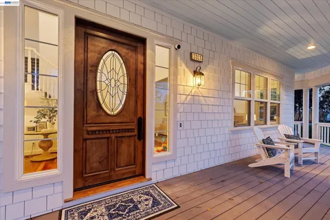 a view of a hallway with wooden floor and a window