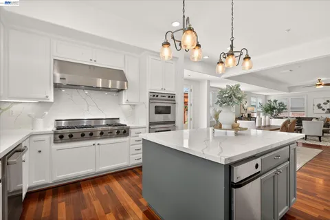 a kitchen with a stove and a wooden floor