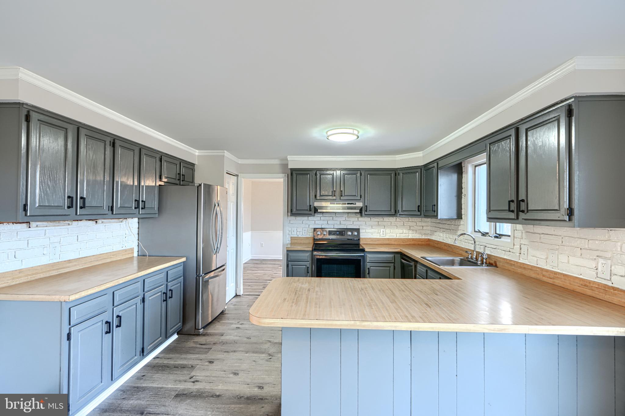 1216 Bachmans Valley Road Westminster, MD 21158 - Photo 18 of 70 a large kitchen with kitchen island a large counter top and stainless steel appliances