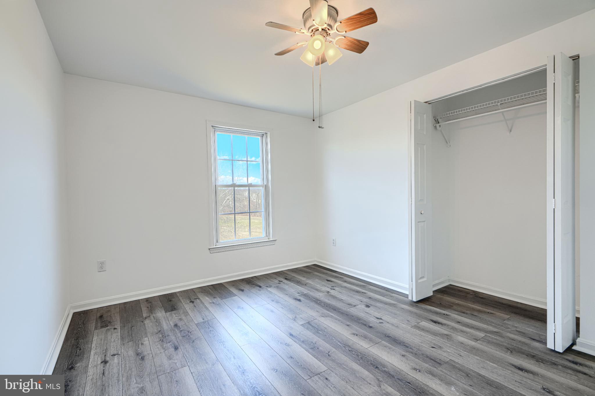 1216 Bachmans Valley Road Westminster, MD 21158 - Photo 34 of 70 an empty room with wooden floor fan and windows