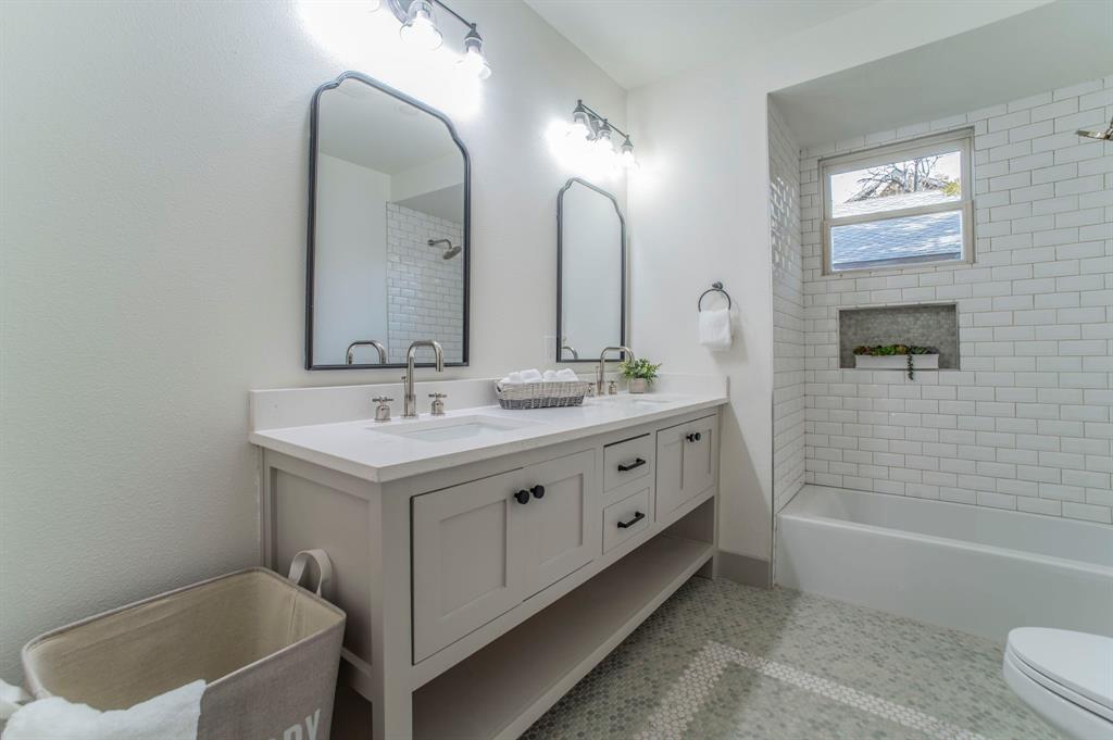 5914 Victor Street Dallas, TX 75214 - Photo 24 of 32 a bathroom with a double vanity sink a toilet and bathtub