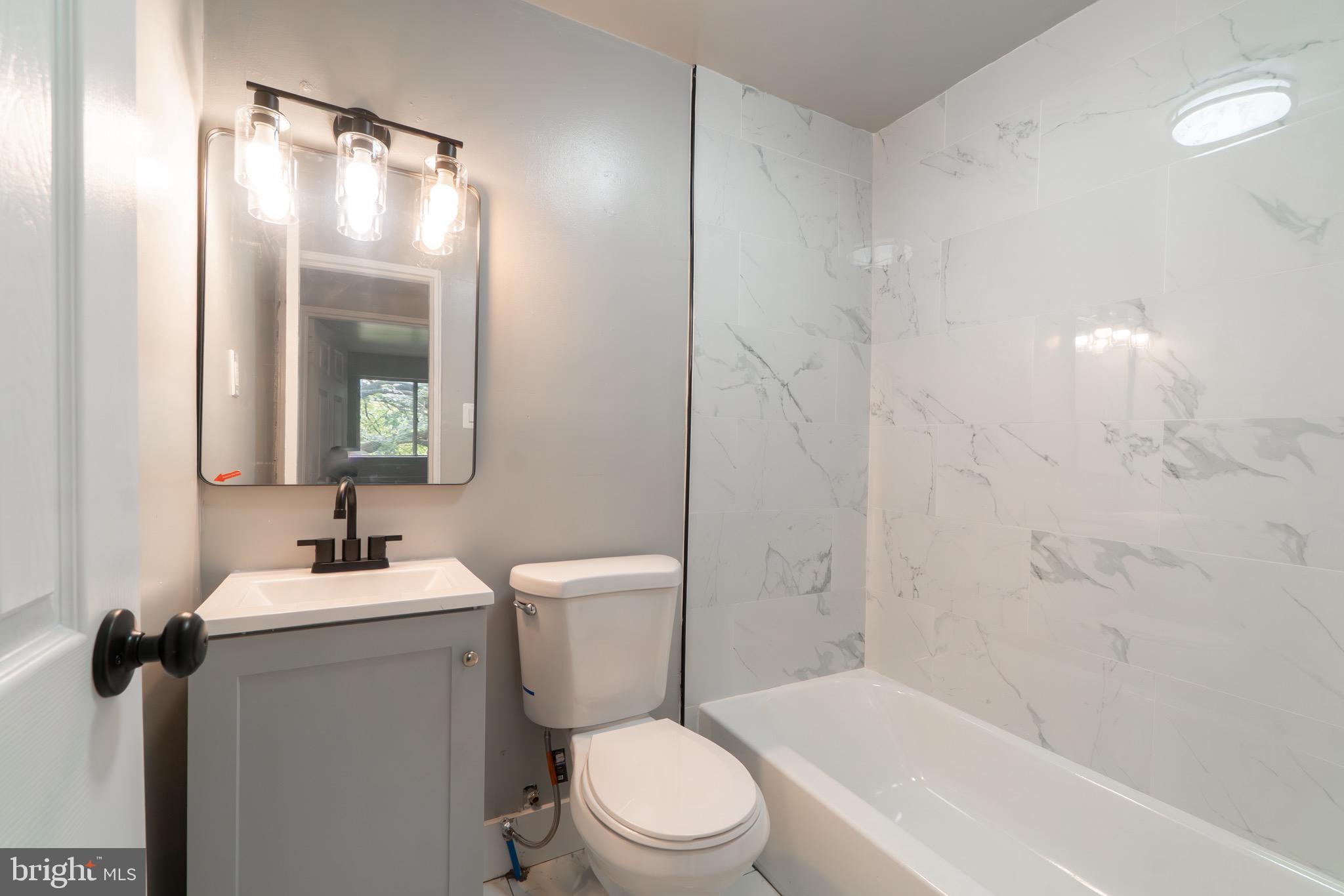 4616 Leiper Street, Unit A1 Philadelphia, PA 19124 - Photo 8 of 12 a bathroom with a sink toilet and shower