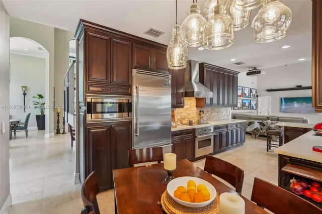 a kitchen with stainless steel appliances granite countertop a stove refrigerator and cabinets