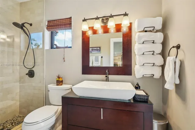 a bathroom with a sink a toilet and shower