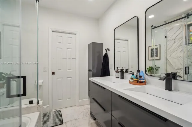 a bathroom with a double vanity sink a mirror and shower