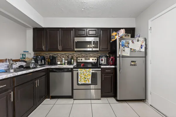 a kitchen with stainless steel appliances granite countertop a refrigerator and a stove top oven