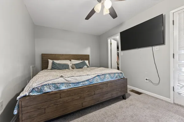 a spacious bedroom with a bed and a flat screen tv