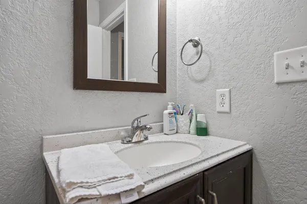 a bathroom with a granite countertop sink and a mirror