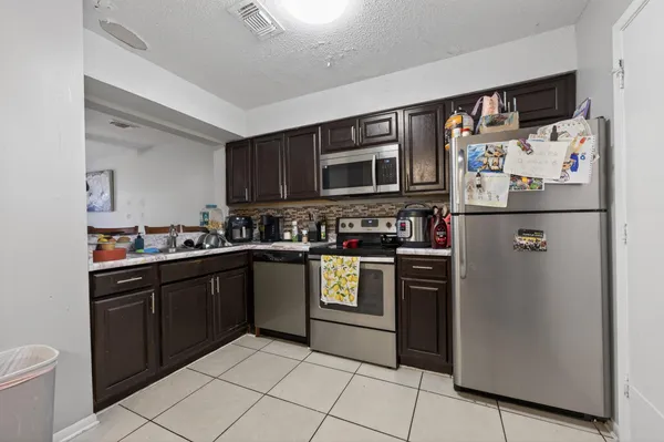a kitchen with stainless steel appliances granite countertop a refrigerator sink and stove