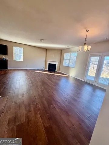 a view of empty room with wooden floor and fireplace