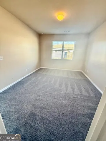 an empty room with a chandeliers fan