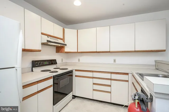 a kitchen with white cabinets and white appliances