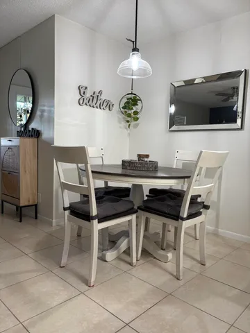 a dining room with wooden floor a chandelier a wooden table and chairs