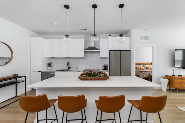 a kitchen with stainless steel appliances a table chairs and a refrigerator