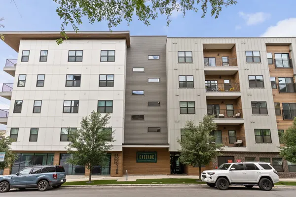 a front view of a residential apartment building with a yard